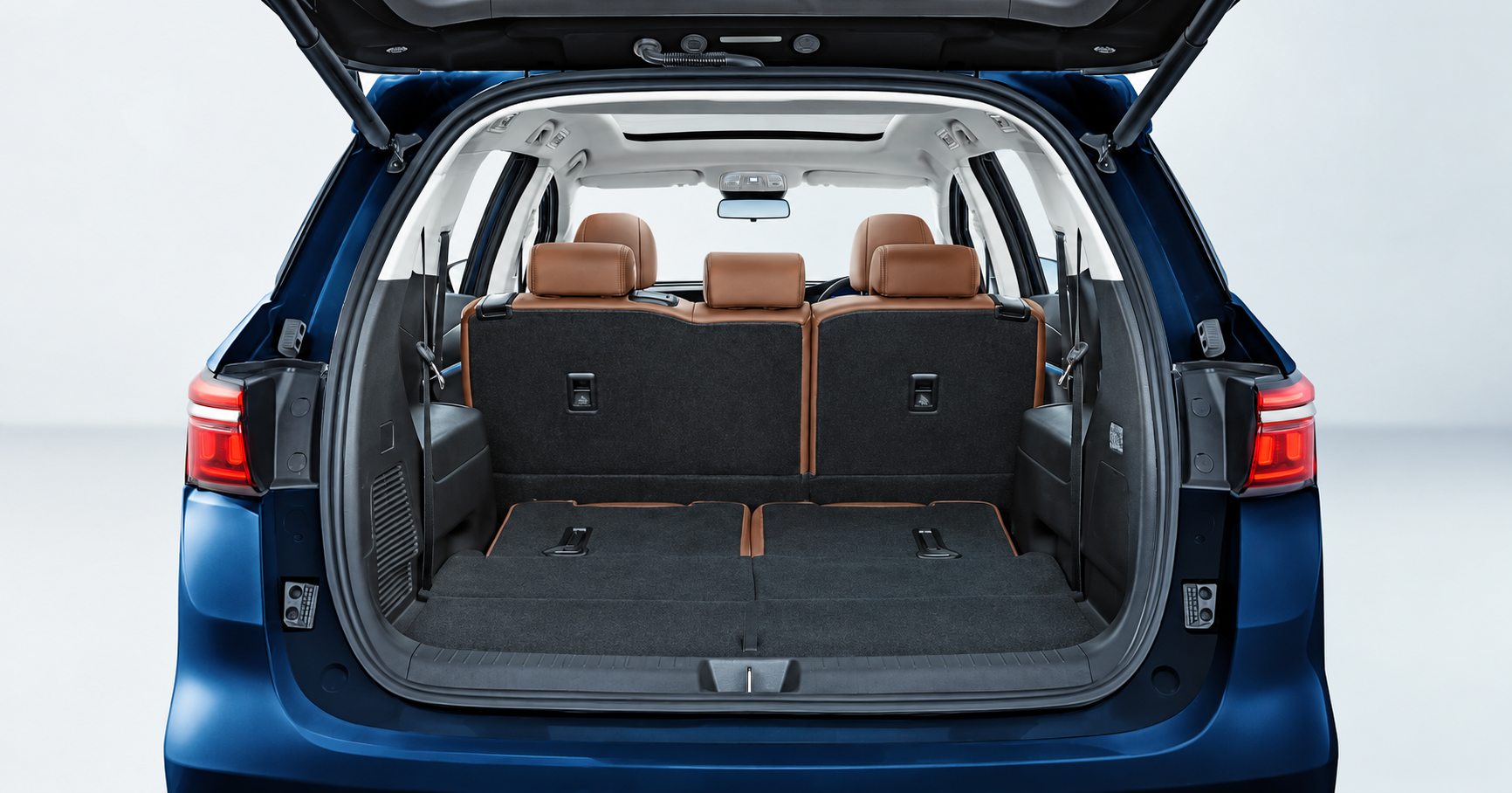Bagasi BYD M6 EV biru dengan pintu belakang terbuka dan kursi baris belakang terlipat untuk ruang kargo